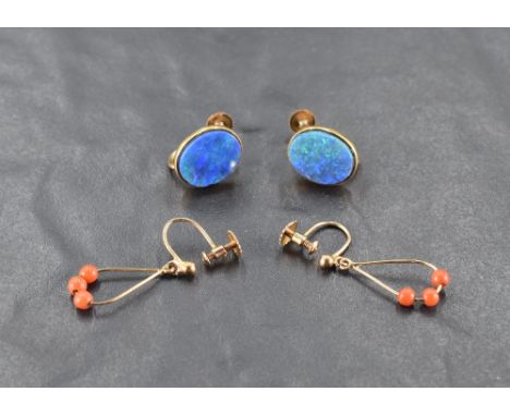 A pair of oval black opal doublet screw back earrings in yellow metal mounts, bearing worn marks, and another pair of yellow 