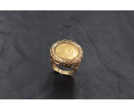 A 9ct gold mounted half sovereign ring, with traditional engine-turned setting and pierced mount and shoulders, marked 375 to