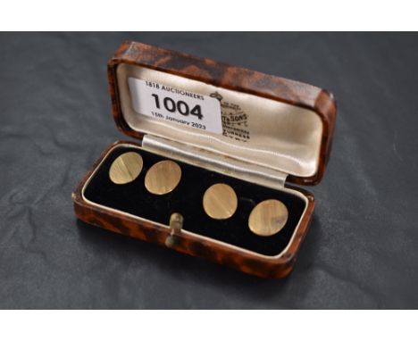 A pair of 9ct gold cufflinks of oval form having engine turned striped decoration and chain connectors, approx 3g