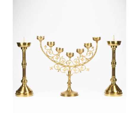 An assembled collection of neogotic candlesticks and a candelabra. The first half of the 20th century. (18 x 61,5 x 56 cm)