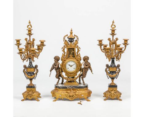 A 3 piece garniture clock in empire style and finished with black marble. The second half of the 20th century. Height candlea