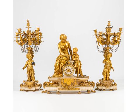 A 3 piece gilt garniture clock, decorated with putti a female figurine and made of alabaster and spelter. 19th century. Heigh