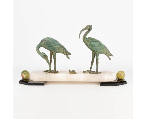 An art deco style statue of 2 ibis birds with a snail, made of spelter on an onyx and marble base. (13 x 46 x 27 cm)