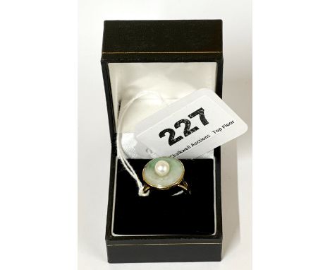 A 14ct yellow gold ring set with a natural jade disk and a cultured pearl, ring size - N.