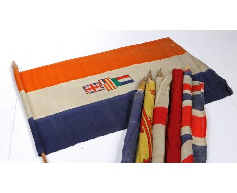 A selection of Early 20th century British and Commonwealth patriotic flags, printed on bunting material, mounted on wooden po