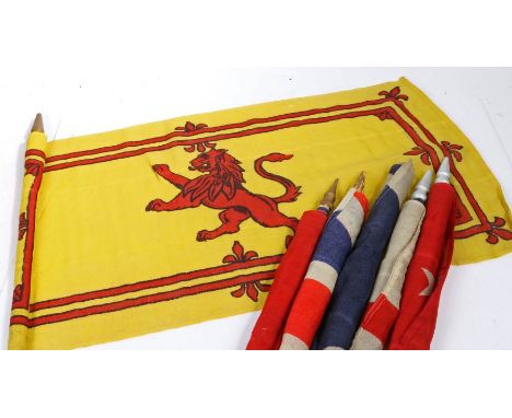 A selection of Early 20th century British and Commonwealth patriotic flags, printed on bunting material, mounted on wooden po