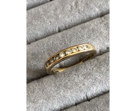 A 9ct HALLMARKED GOLD EIGHT STONE DIAMOND CHANNEL SET HALF ETERNITY RING. FINGER SIZE M. WEIGHT 2.12grms.