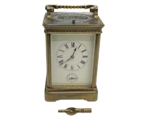 An early 20th century French brass cased repeating carriage clock, the white enamel dial set with Roman numerals and subsidia