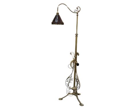 A late 19th/early 20th century brass framed standard reading lamp, with coloured leaded glass shade, height 157cm.