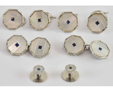 A cased set of 9ct white gold and enamelled cufflinks, buttons and studs in the Art Deco manner, with central blue cut sapphi