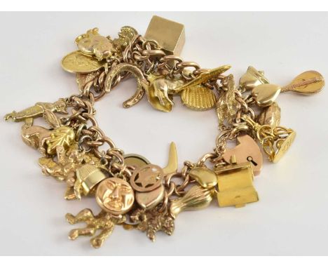 A 9ct gold charm bracelet, with approximately thirty-six charms including St Christopher, cased ten shilling banknote, house,