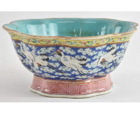 A 19th century Chinese blue ground porcelain bowl, decorated with birds and clouds, and with yellow foliate border, with Qian