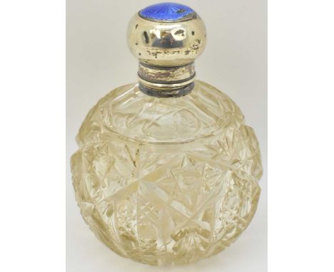An early 20th century cut glass perfume bottle, with silver and blue enamelled lid and small inner stopper, height 13cm.
