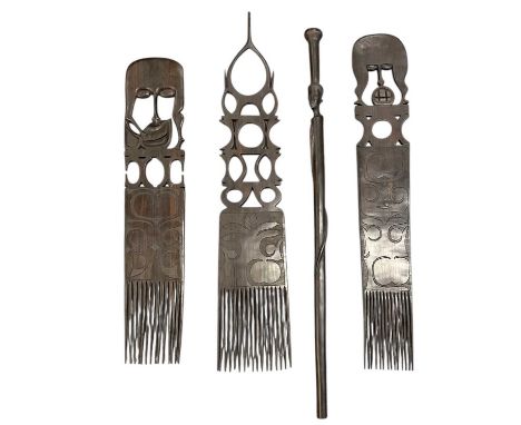 Three large African carved wooden combs, length of largest approx 90cm, and an African carved wooden figural walking stick, c