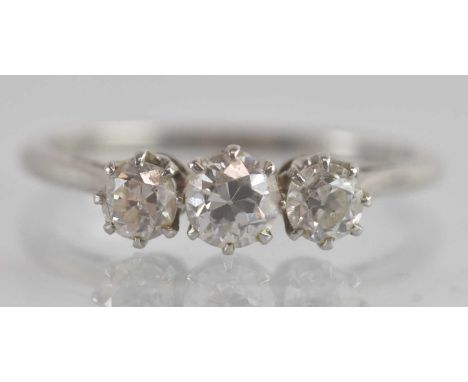 A platinum three stone diamond set ring, the central stone approx 0.3ct, flanked by two smaller claw set stones, each approx 