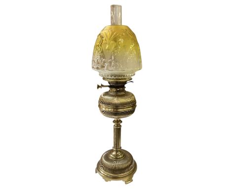 A late Victorian brass oil lamp, with clear glass chimney and yellow etched glass shade, height to top of chimney 65cm.
