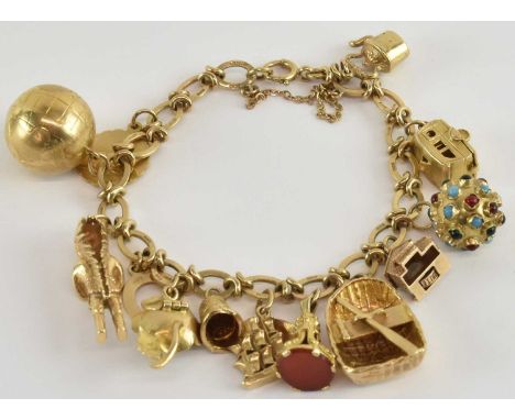 A 9ct gold charm bracelet, with approximately thirteen gold charms including a globe, rowing boat, caravan, Native American c