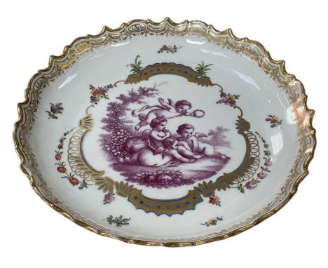 An early 20th century Continental porcelain plate, the central panel decorated with four cherubs, surrounded by foliate gilt 