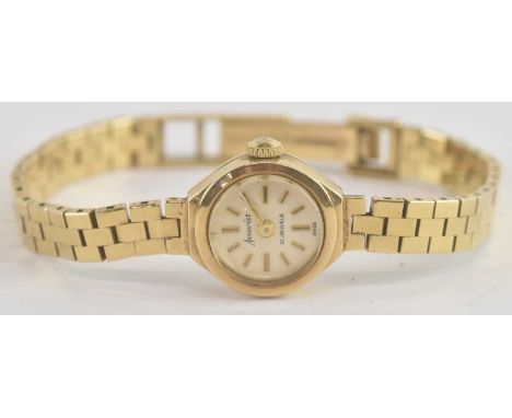 ACCURIST; a lady's 9ct gold wristwatch, the champagne dial set with baton markers, crown wind movement, in a 9ct gold head an