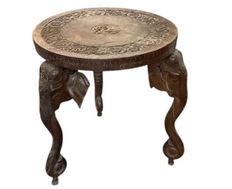A late 19th/early 20th century Anglo-Indian profusely carved circular tripod side table, the legs modelled as elephant heads,