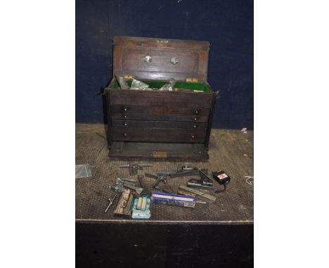A VINTAGE OAK ENGINEERS TOOLCHEST WITH TEST AND MARKING EQUIPMENT with four drawers concealed by a lift off front and hinged 