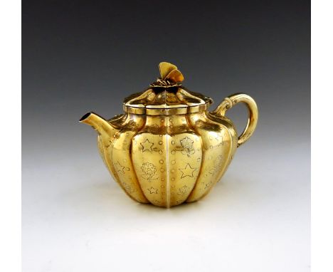 λA George III silver-gilt bachelor's teapot, by Charles Price, London 1818, fluted melon form, scroll handle with ivory insul