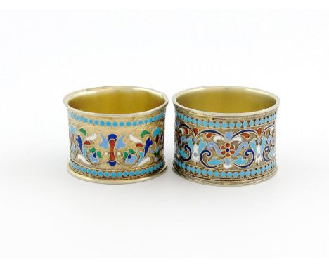 Two Russian silver-gilt and enamel napkin rings, various dates, circular form, with varied coloured foliate scroll enamel dec