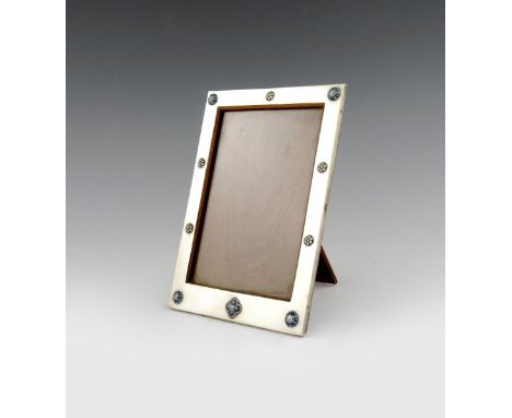 By Liberty and Co, a silver and enamel photograph frame, Birmingham 1917, rectangular form, applied with blue/green enamel de