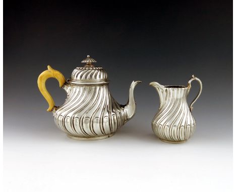 λA Victorian silver teapot and cream jug, by The Barnards, London 1862 and 1863, swirl fluted pear form, domed cover with a f
