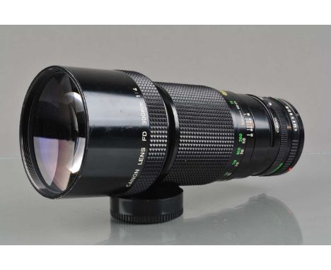 A Canon FD 300mm f/4 Lens, serial no 22665, barrel G, some light wear/scratches to hood, elements G-VG, with Canon Regular 1x