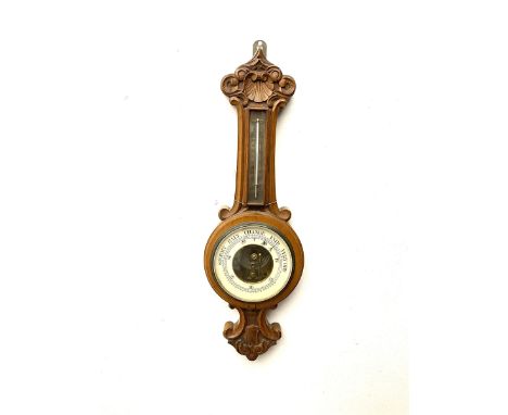 Early 20th century walnut cased aneroid barometer, the pediment carved with scrolls and shell, mercury thermometerDimensions: