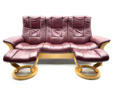 Ekornes 'Stressless' three seat sofa upholstered in cranberry leather and two matching footstooldDimensions: Height:&nbsp;103