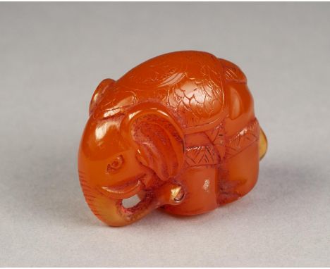 LATE NINETEENTH CENTURY JAPANESE CARVED AMBER NETSUKE, modelled as a caparisoned elephant, signed, 14.5gms