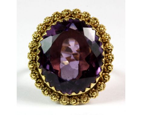 A yellow metal (tested 18ct yellow gold) ring set with a large oval cut amethyst (K).
