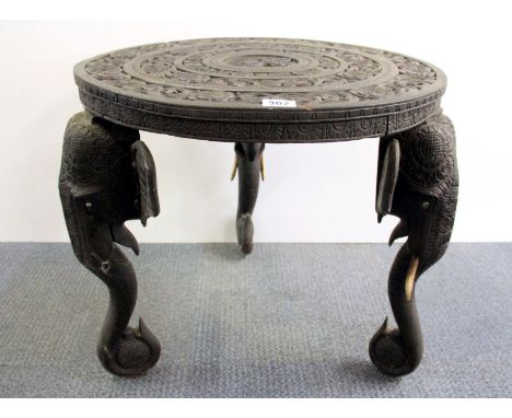 An early 20th century Indian carved table with elephant trunk legs, Dia. 60cm, H. 59cm.