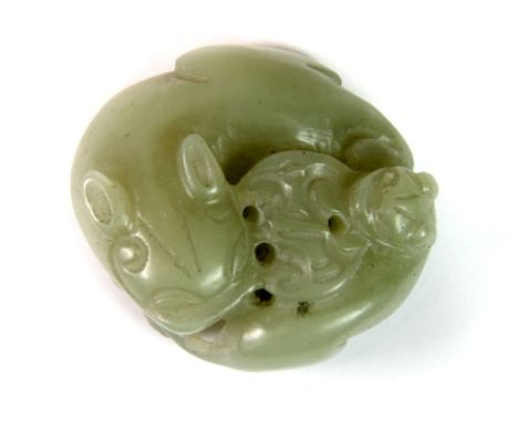A small Chinese carved celadon green jade amulet of a dragon and baby probably 19th century, D. 4.5cm.