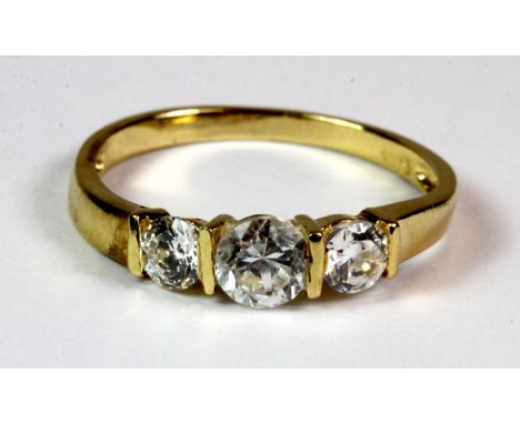 An 18ct yellow gold ring set with three brilliant cut stones (K).