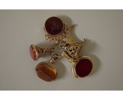 Three gold swivel seals; together with two unmarked seals, attached to a metal ring. 