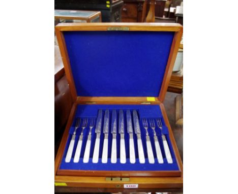 A mahogany cased set of twelve mother of pearl handled silver plated fruit knives and forks.&nbsp; 