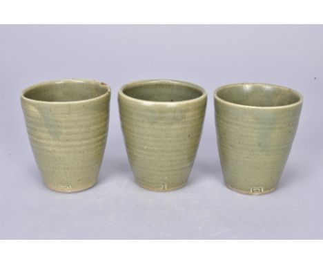 DAVID LEACH (1911-2005) for Lowerdown Pottery; a group of three stoneware beakers covered in green celadon glaze, impressed D