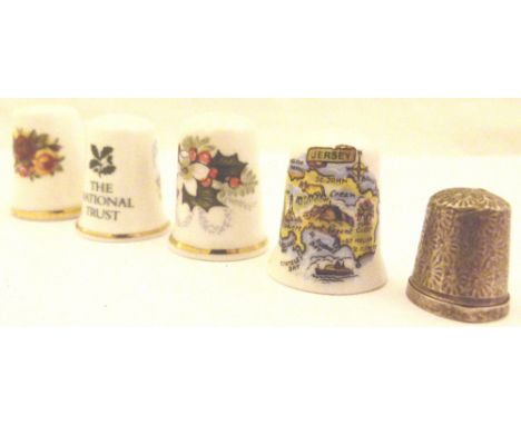 Four ceramic thimbles and a hallmarked silver example