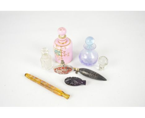 A small collection of scent bottles including an oval example with silver overlay and pink ceramic example decorated with gil