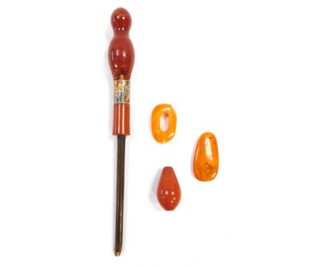 A group of amber, comprising a cherry amber parasol handle, with enamel gilt collar (AF), a further cherry amber bead and two