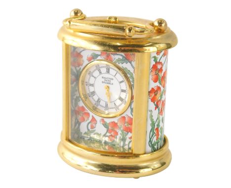 A Halcyon Days Enamels miniature carriage clock, of oval form, decorated with flowers, with swing handle, 8cm high.