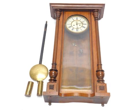 A late 19thC/early 20thC Vienna walnut wall clock, the dial with Roman numerals, flanked by turned pilasters, 82cm high.