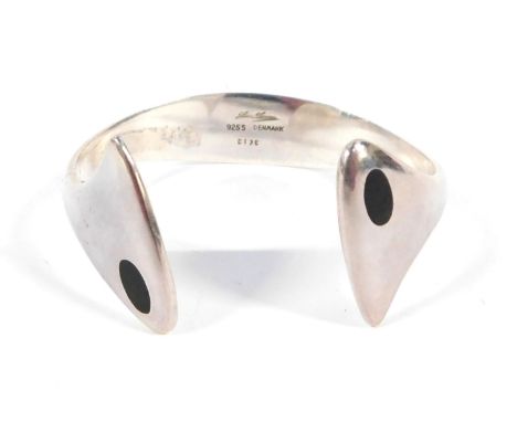 A Hans Hanson Danish bangle, the two shaped fronts with black enamel detailing, on a shaped back, stamped Denmark 213E, white