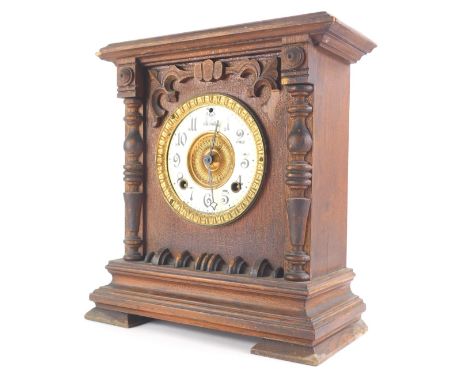 An early 20thC Ansonia oak cased mantel clock, with raised carvings, quarter columns, 12cm dia. Arabic enamel dial and compre