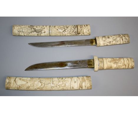 Two Japanese carved bone tanto daggers, Meiji period, each with handle and scabbard carved in shallow relief with figures in 