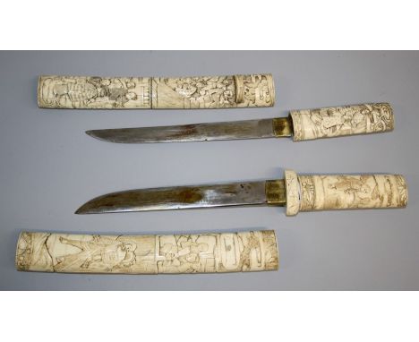 Two Japanese carved bone tanto daggers, Meiji period, each with handle and scabbard carved in shallow relief with figures in 