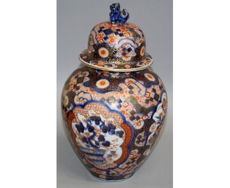 A late 19th century Japanese Imari baluster vase and cover, with kylin finial, decorated with reserves of flowering basket an